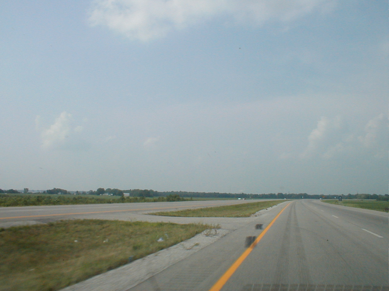A newly four-laned section of US 60 east of Owensboro. The smoke stack and cooling towers of the Rockport power plant and the towers of the Natcher bridge are faintly visible.